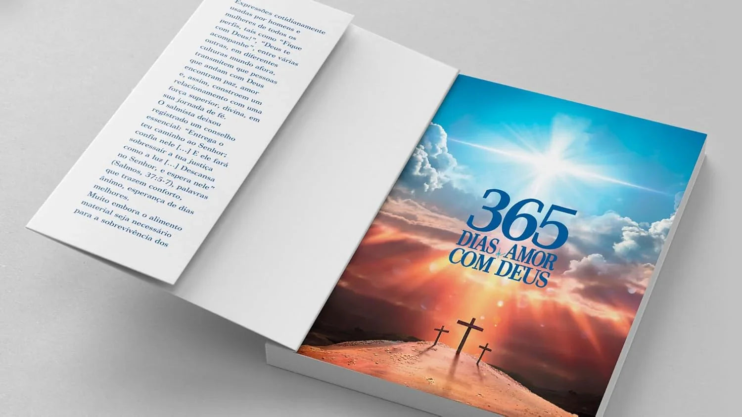 Livro aberto sobre mesa com capa mostrando céu com sol e três cruzes, título 365 Dias de Amor com Deus